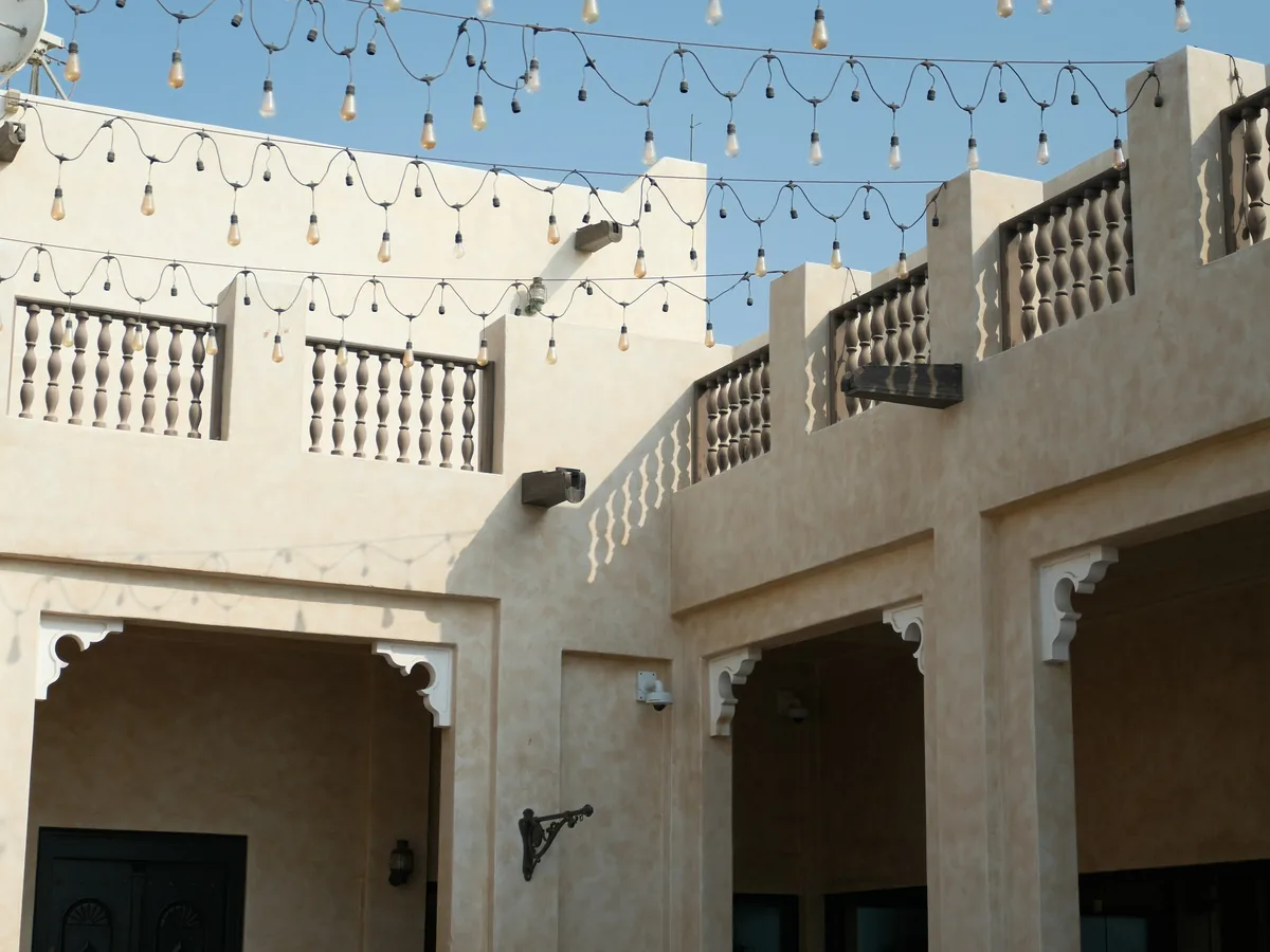 A courtyard strung with warm lights at night
